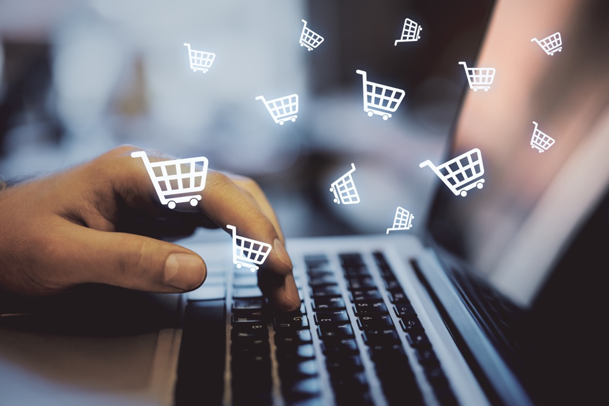 A person clicking a buy button while online shopping on a laptop