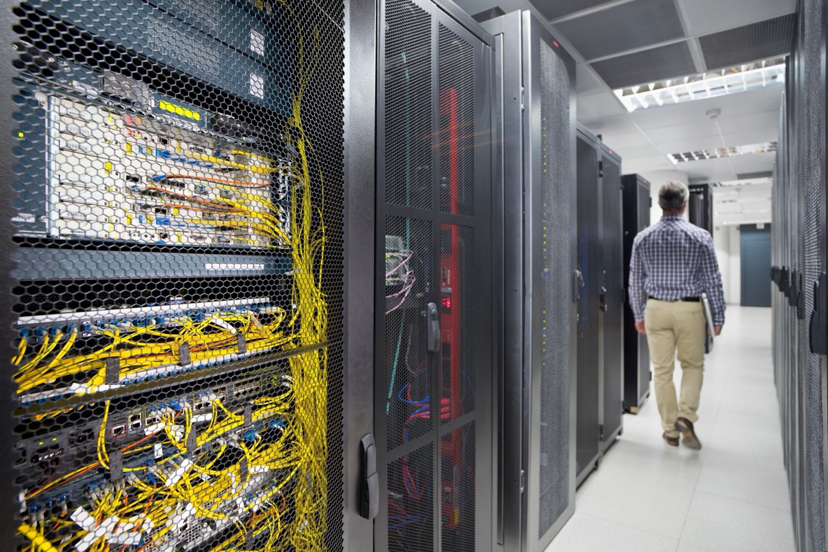 A figure in the aisle of a data center