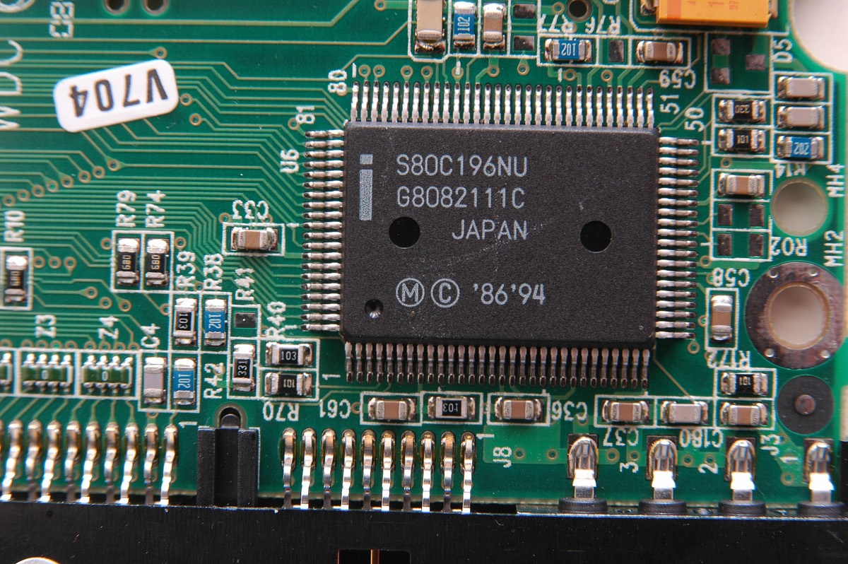 Close-up of a vintage computer circuit board with ROM memory chips and copper traces
