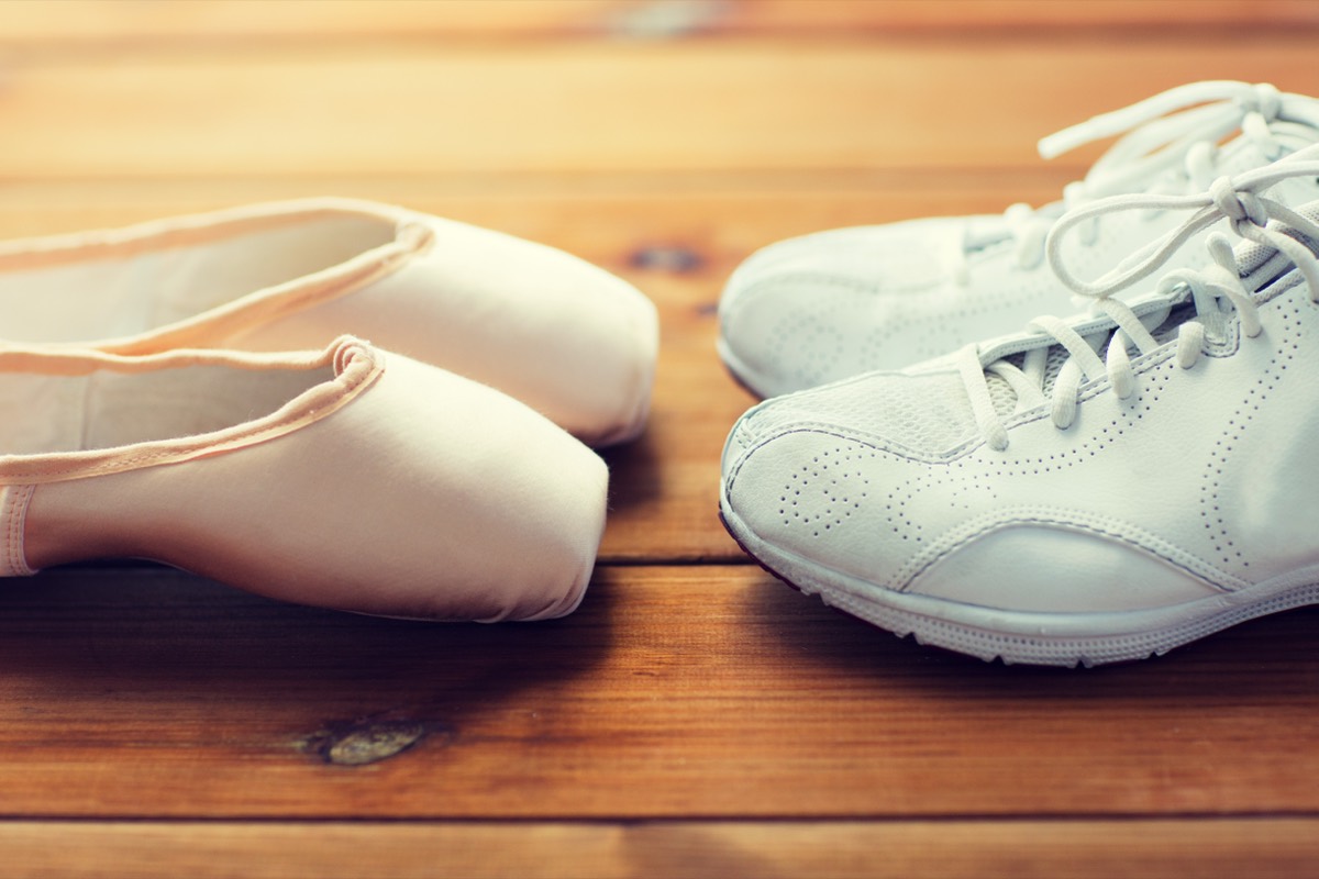 A pair of black-and-white dance shoes on a wooden ballroom floor