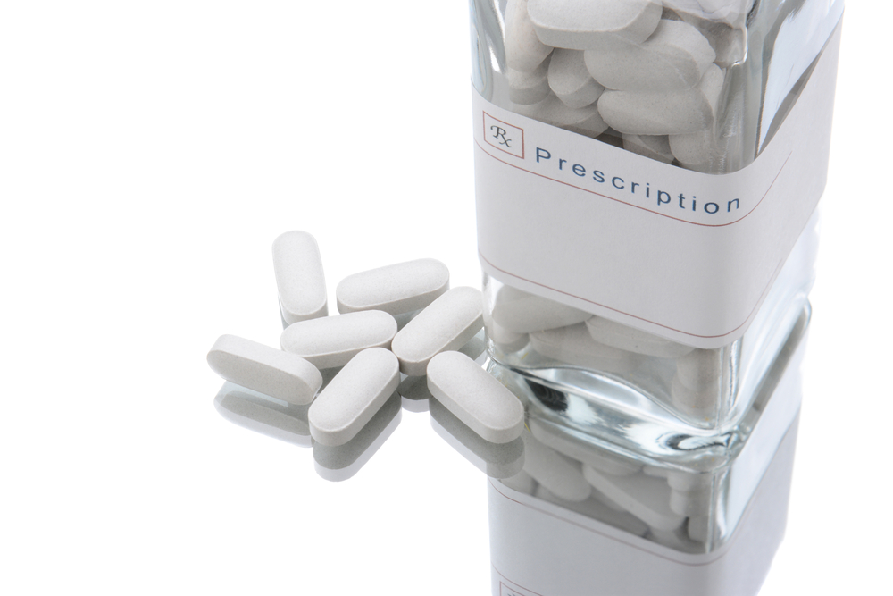 Loose white round tablets scattered on a plain surface