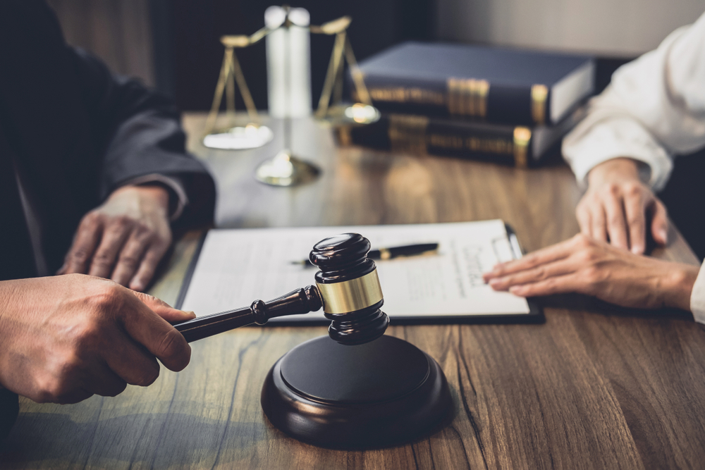 A judge's gavel resting beside legal documents on a courtroom bench