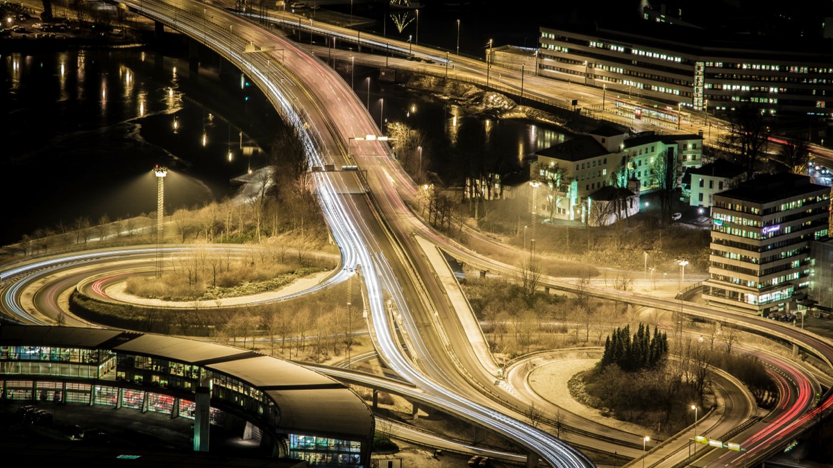 Long-exposure night photograph of a busy city street with car headlights and taillights rendered as streaks of light