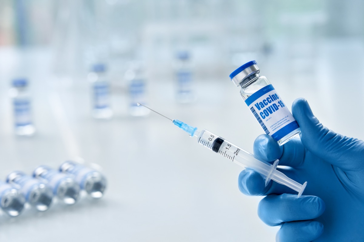 A scientist holding a laboratory vial in a research lab