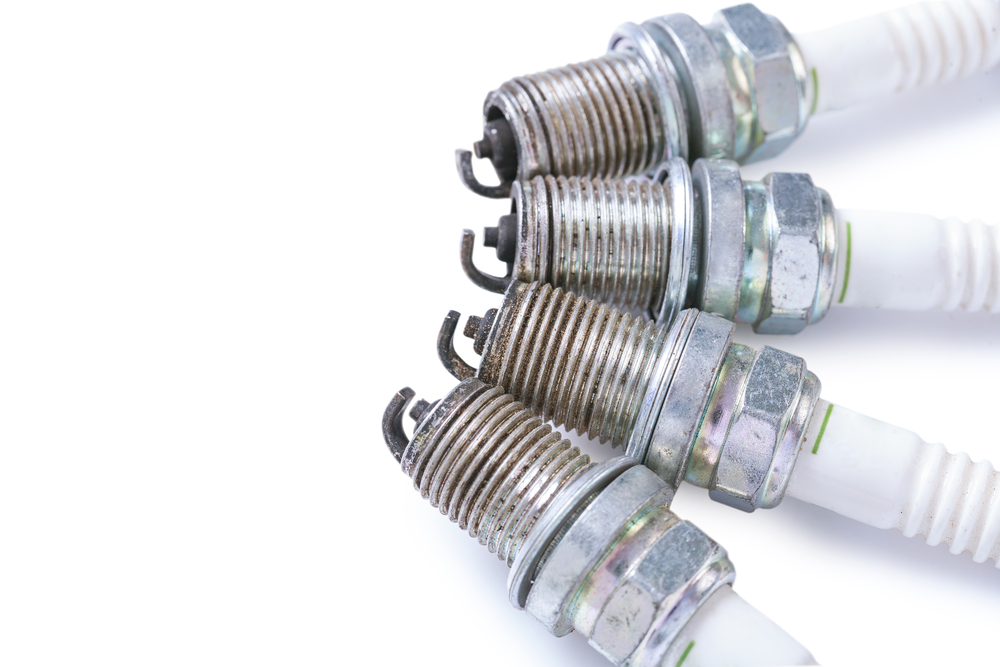 Used and reconditioned spark plugs arranged on a mechanic's workbench