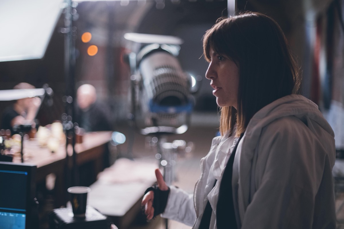 An actress performing in front of a film camera and crew on a soundstage