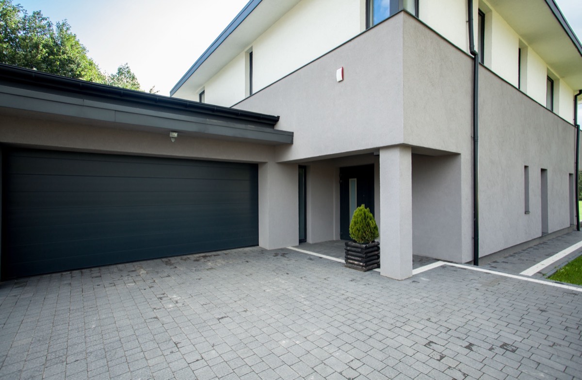 A residential garage door opening with an electronic remote control in the foreground