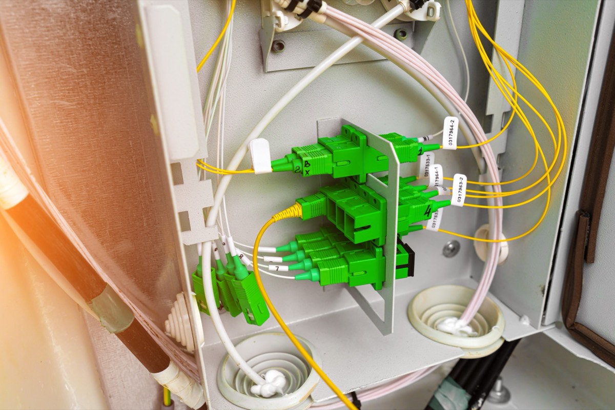 Rows of illuminated network servers and fiber-optic cabling in a data center