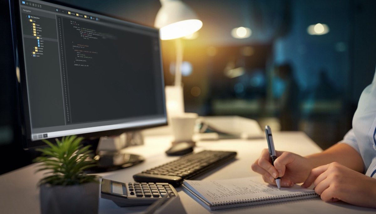 Lines of computer source code displayed on a dark monitor in a developer workspace