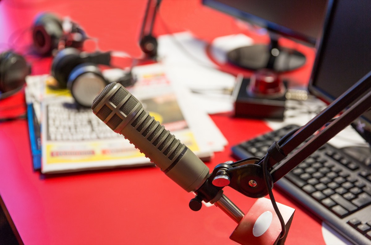 A radio broadcast microphone in front of an audio console