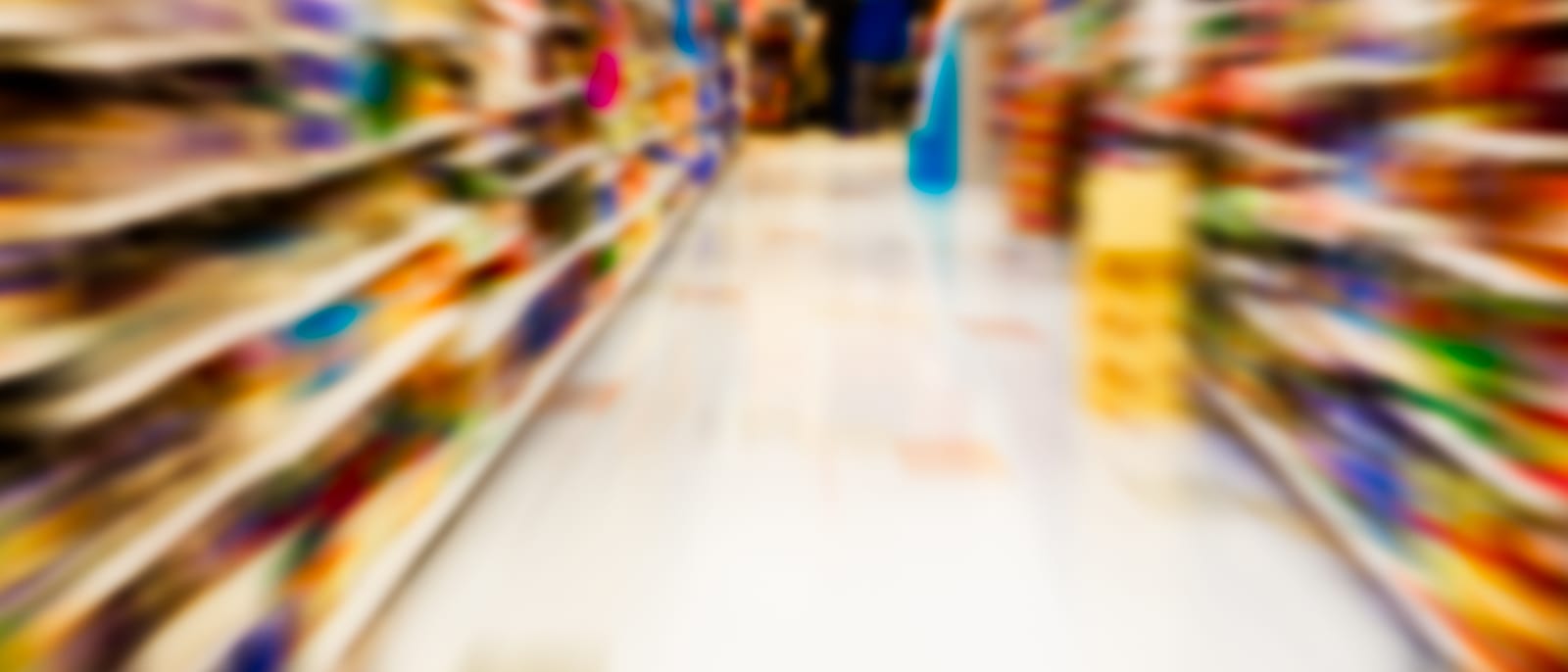 Rows of stocked grocery store shelves under fluorescent lighting
