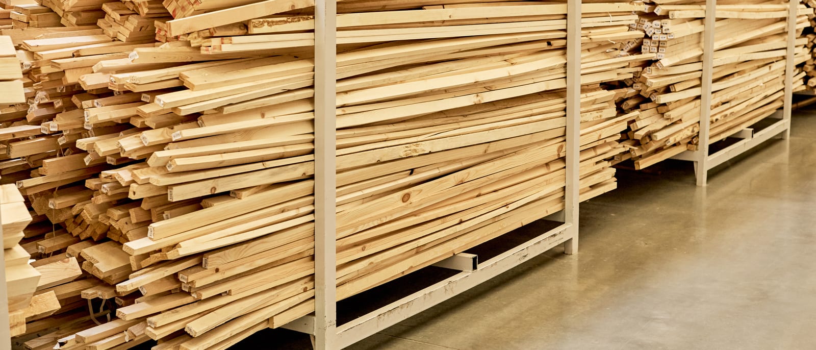 Stacked sheets of plywood and lumber in an industrial timber warehouse