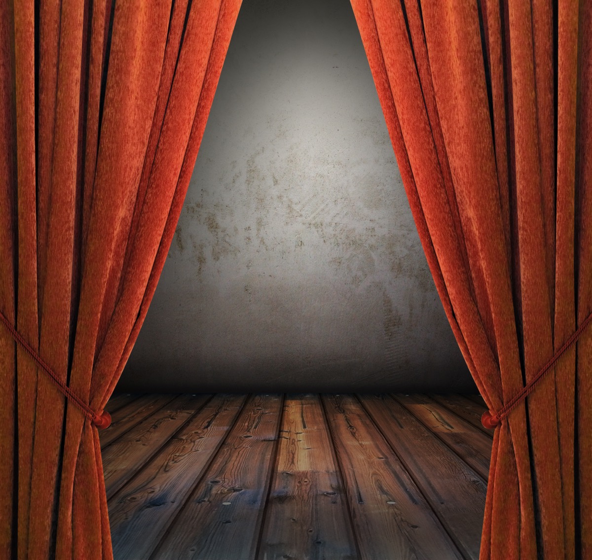 An empty Broadway theater stage with red curtains and stage lights