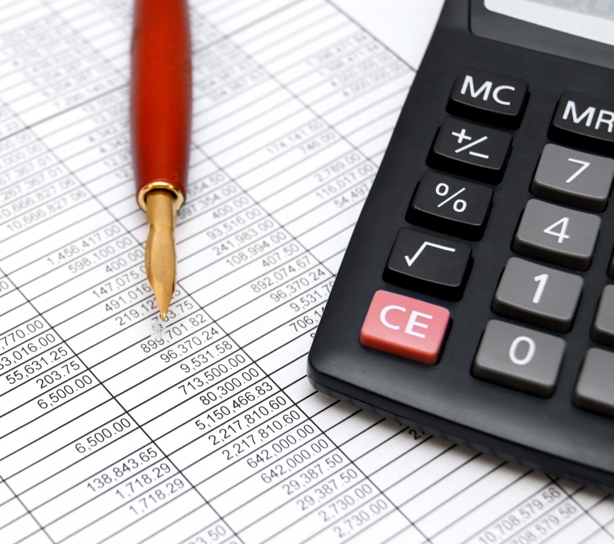 Calculator and gavel on a desk beside a spreadsheet of damages figures