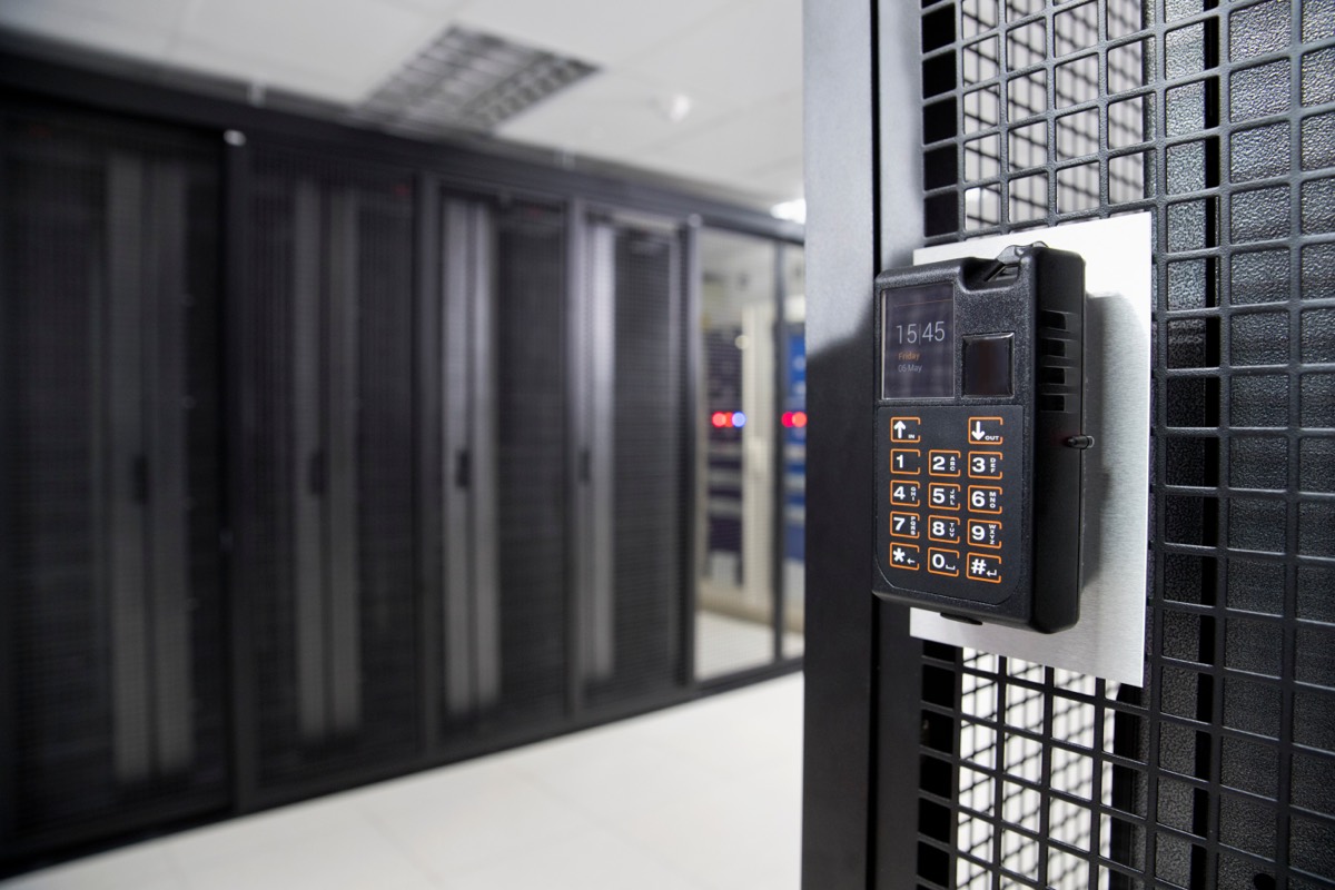 Engineer swiping a keycard at a secure server room door in an office building