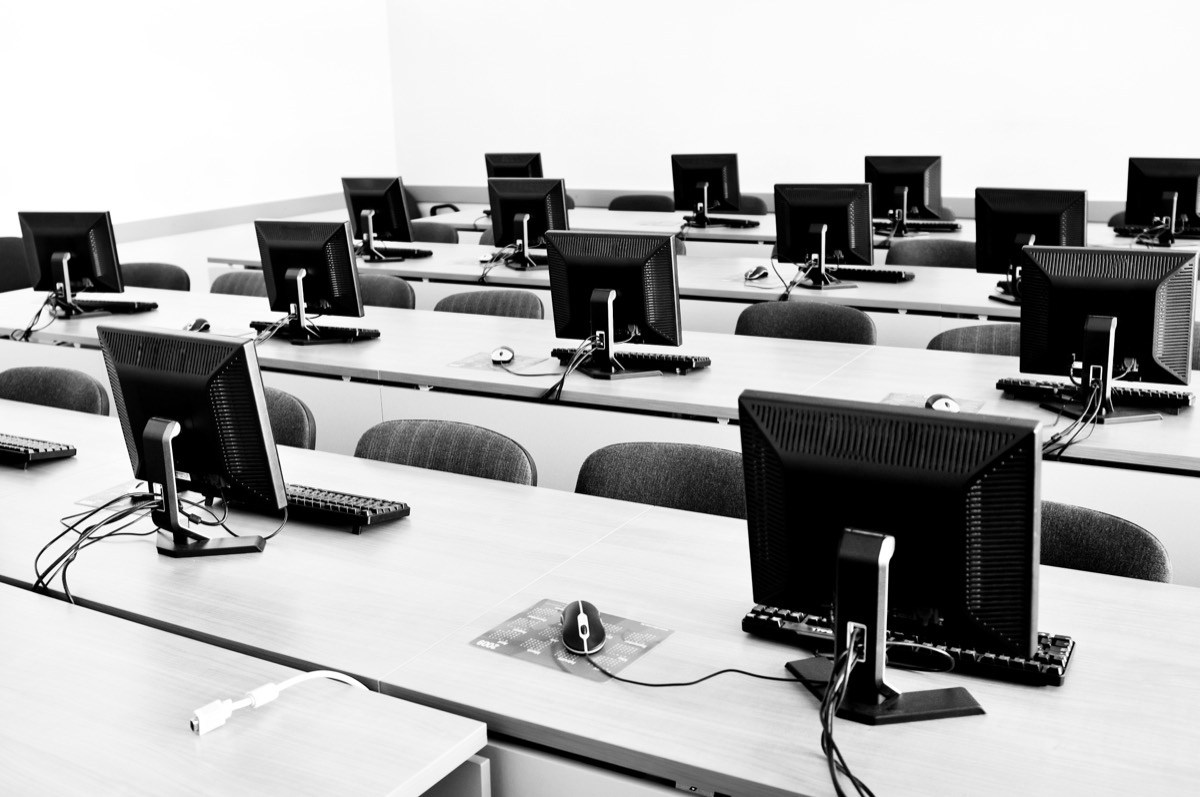Trust and safety analyst reviewing flagged content on multiple monitors in an office