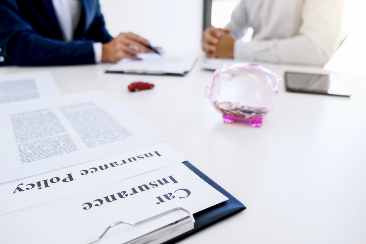 Business insurance policy documents and a pen arranged on a conference table