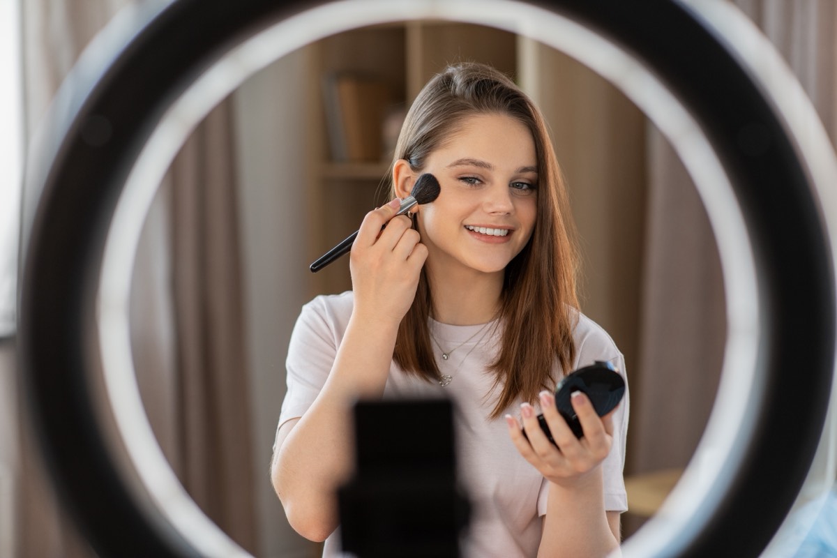 Content creator filming a product review on a phone with a ring light