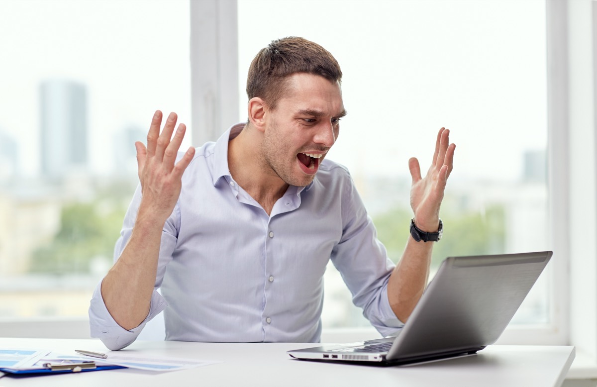 A stressed founder reviewing legal problems at a laptop late at night