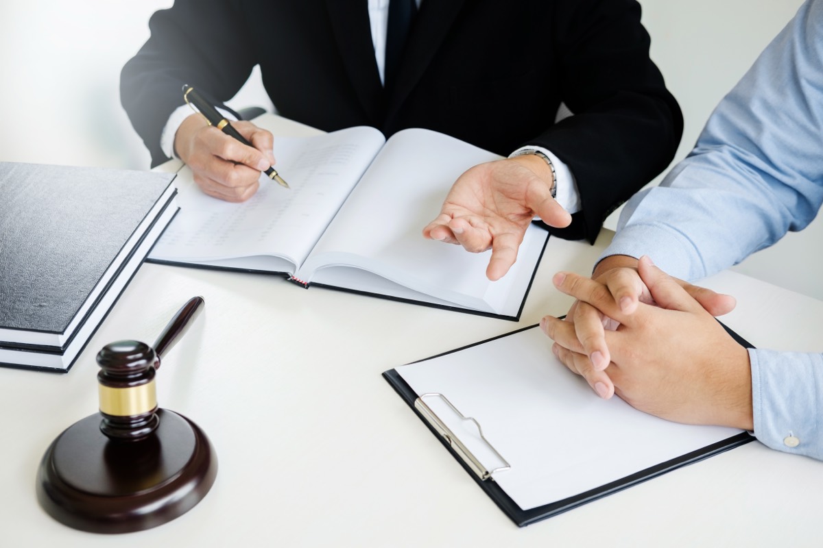 Business owner and attorney reviewing a federal court summons across a conference table