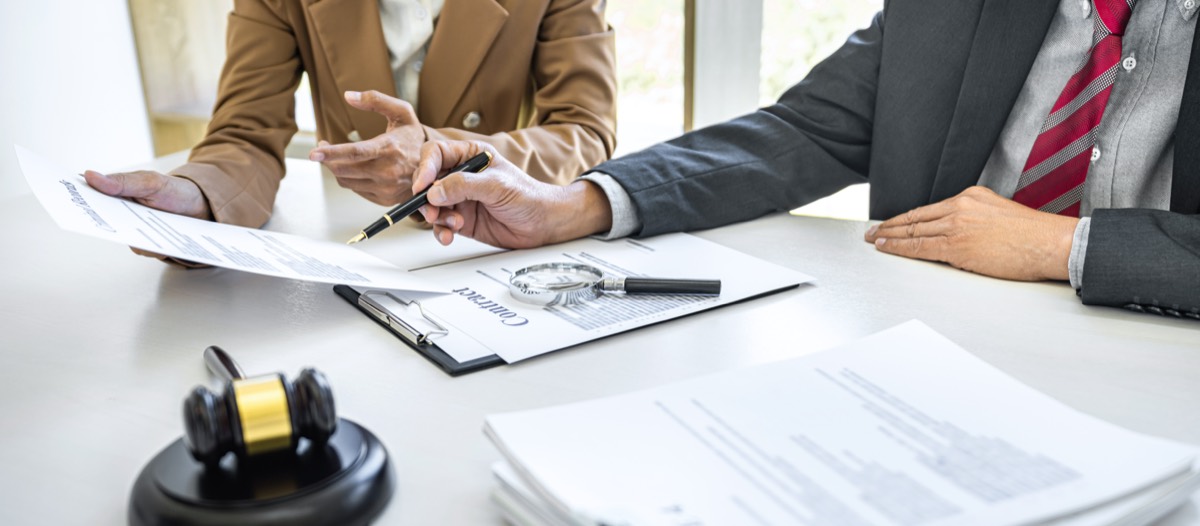 Business owner reviewing a federal court complaint with an attorney in a law office