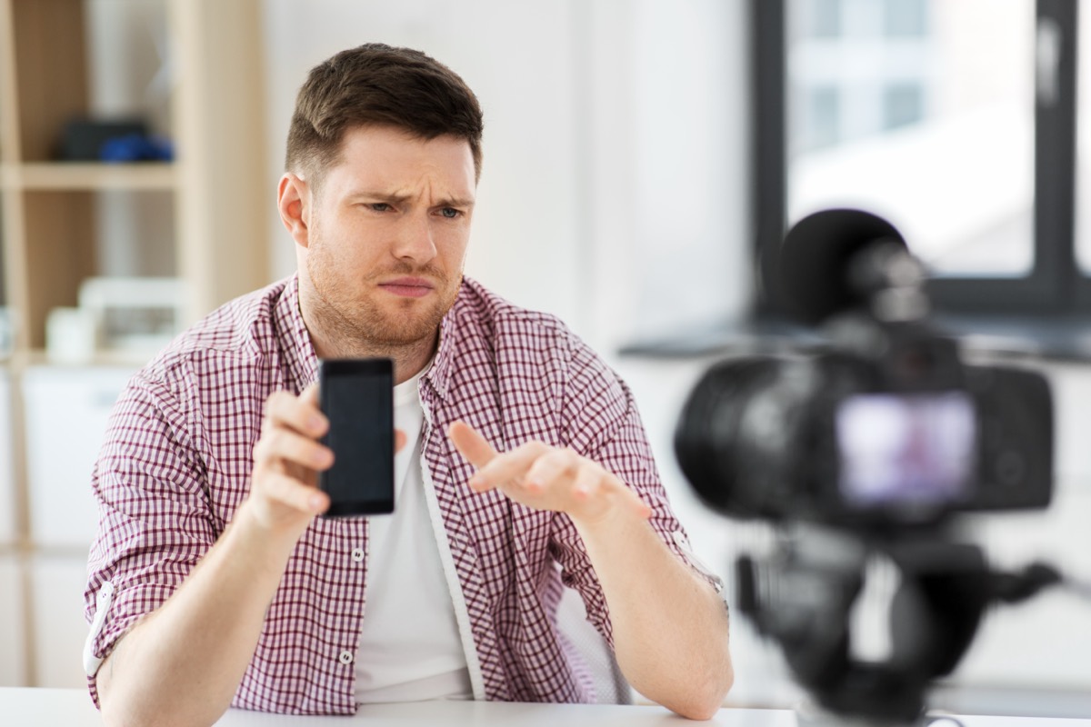 Marketing team filming a vertical smartphone video of a product on a small set with softbox lights