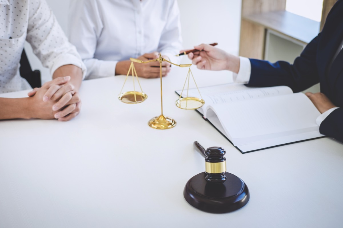 A lawyer and executive reviewing documents urgently in a conference room