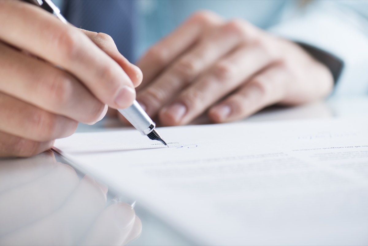 A red cancelled stamp on a legal document on a desk