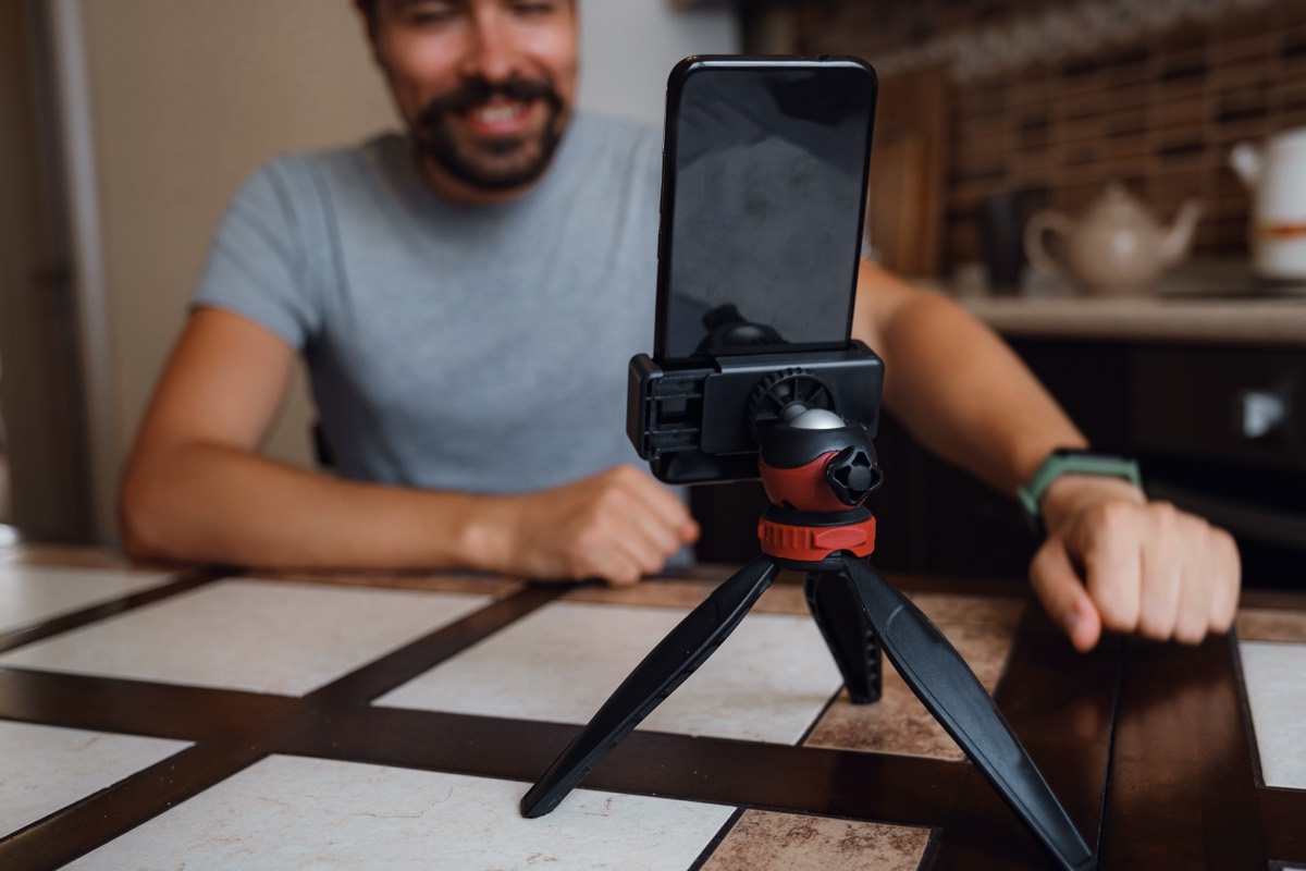 Smartphone on a tripod playing a video with a play button on screen