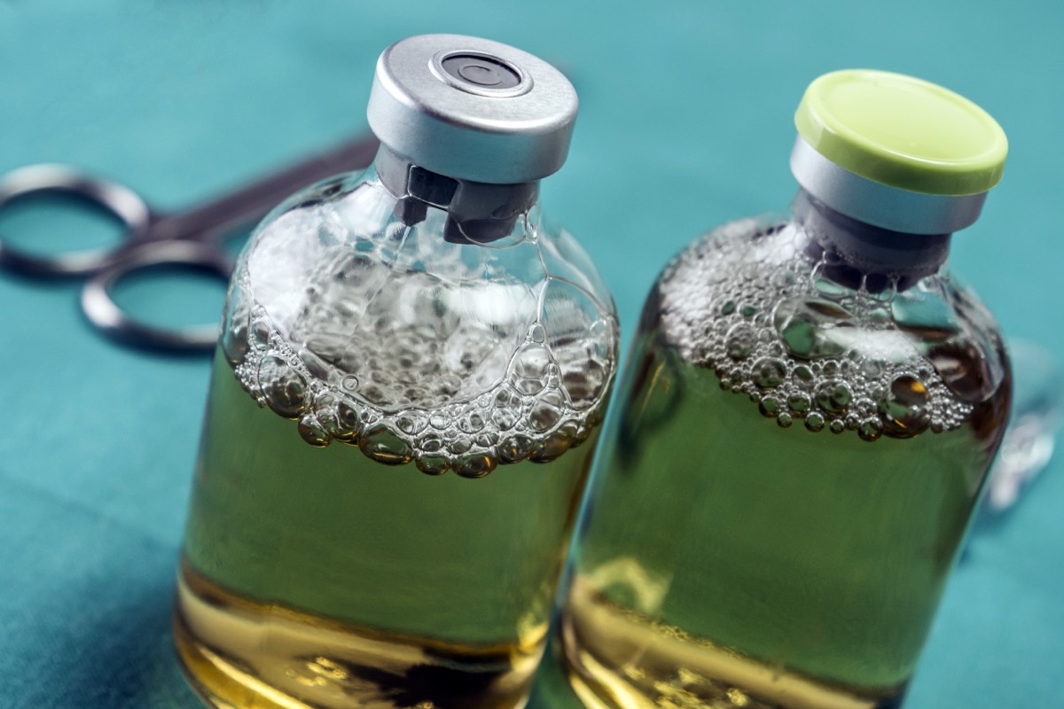A Pacific yew tree branch beside laboratory vials representing anticancer drug research