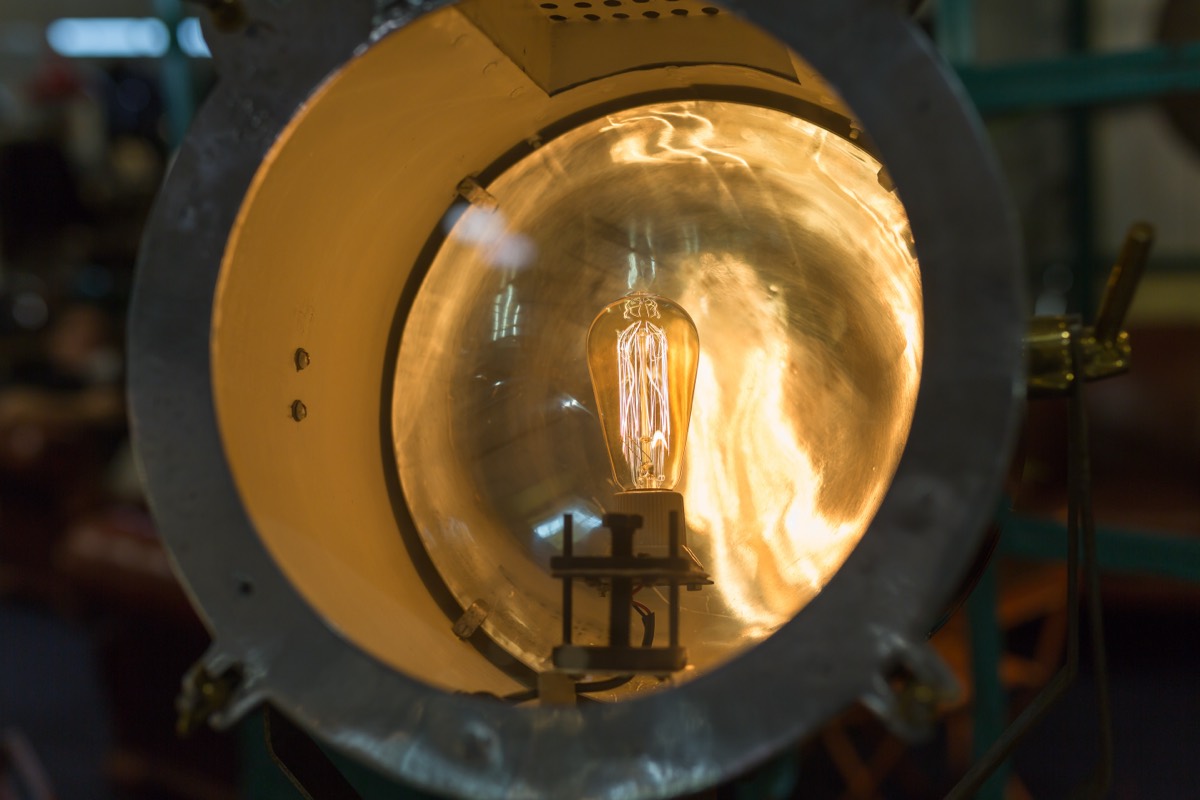 A vintage incandescent light bulb showing a glowing carbon filament