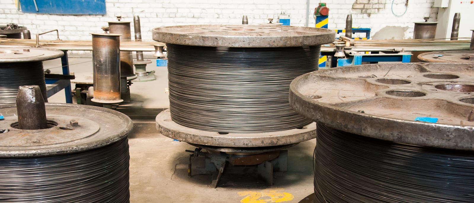 Coils of industrial electrical wire and ceramic insulators on a warehouse shelf