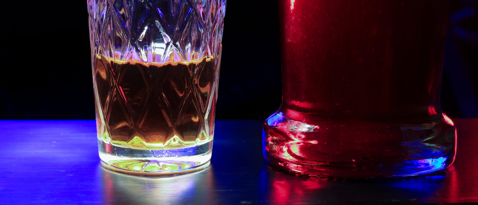 An amber liquor bottle backlit on a polished bar shelf