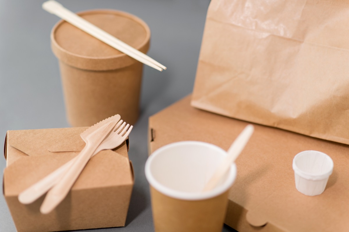 Paper takeout boxes and napkins stacked at a fast-food counter