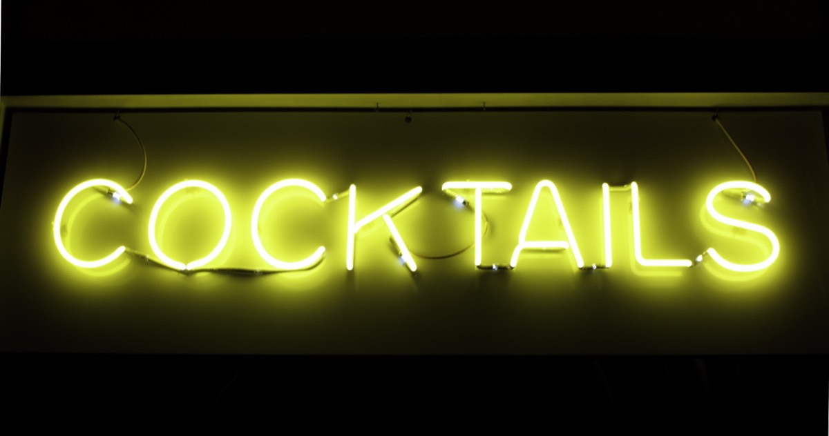 Neon sign glowing outside a roadside barbecue restaurant at dusk