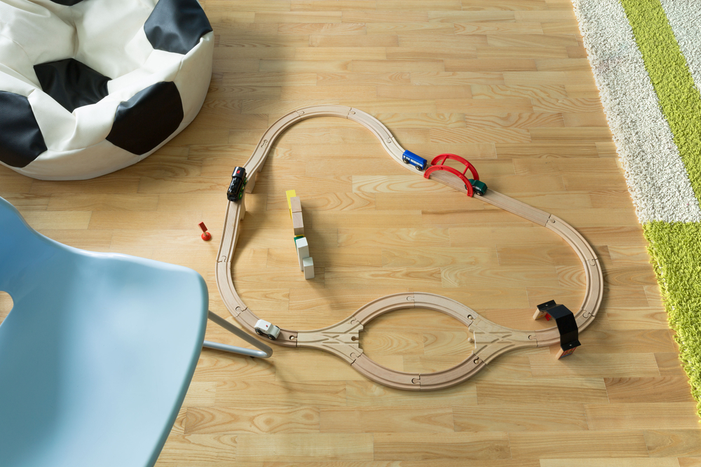 A child's wooden toy train on a curved section of wooden track