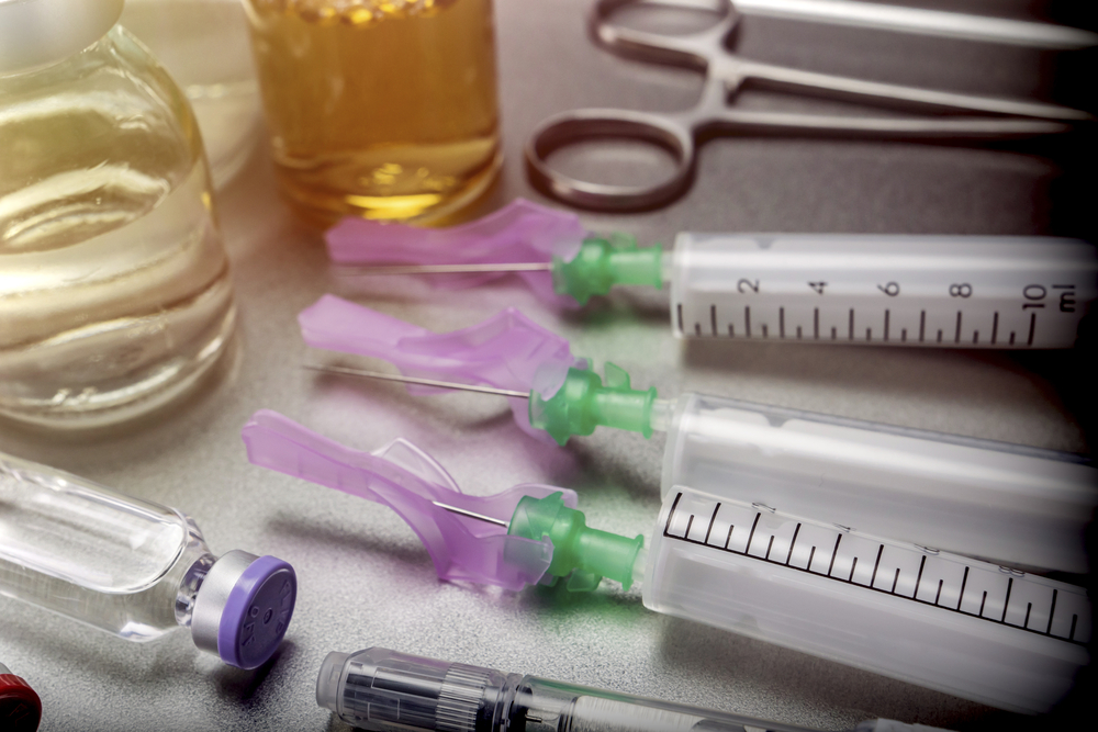 Rows of small glass biologic medicine vials on a laboratory bench