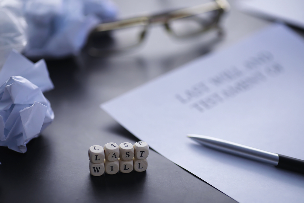 A person signing a legal document with a fountain pen at a desk