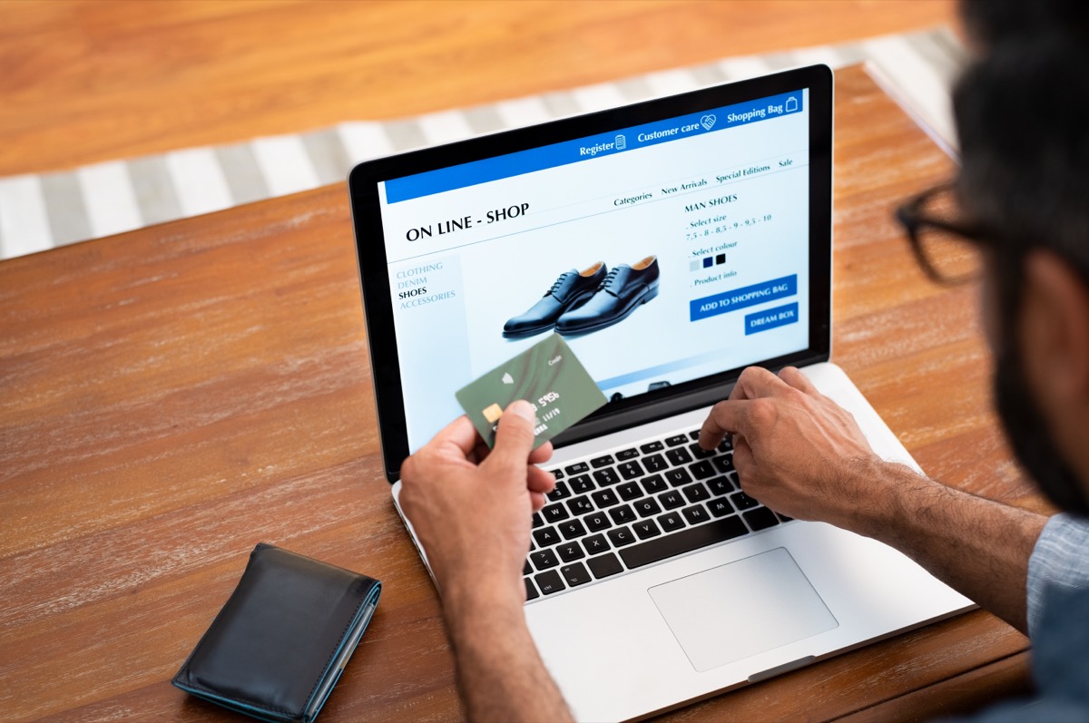 A hand entering a credit card number into an online payment form