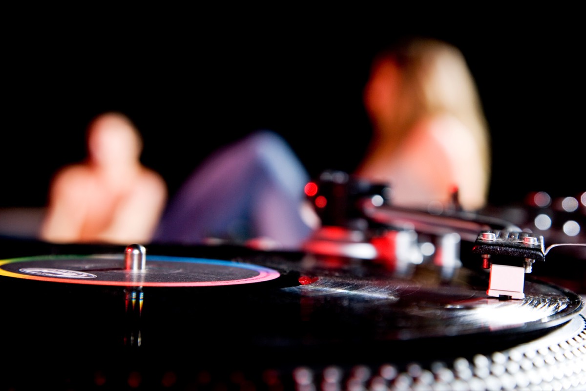 A vintage vinyl record spinning on a turntable in warm light