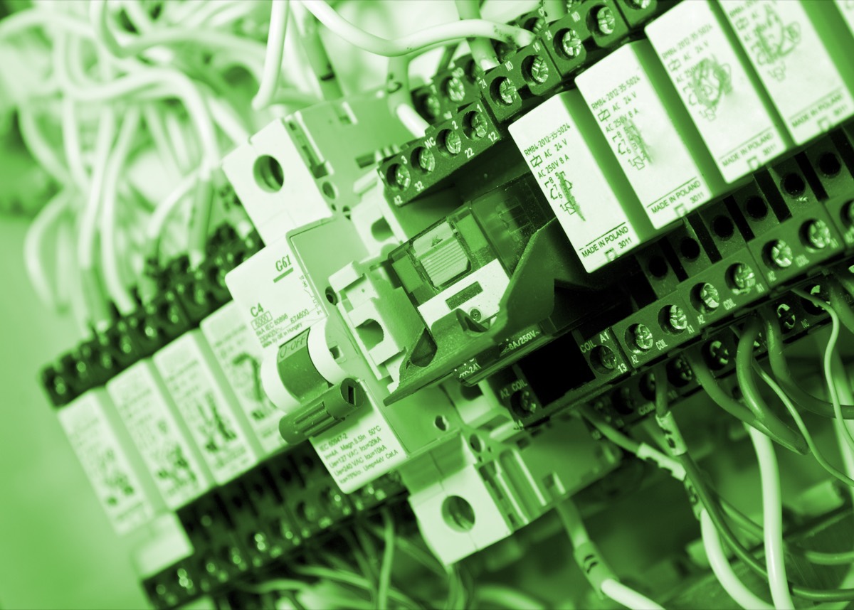 Bundled electrical wires held by plastic cable ducts on an industrial panel