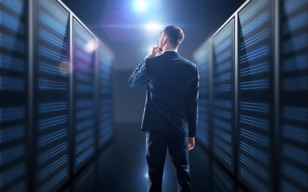 Server room corridor with rows of illuminated data servers