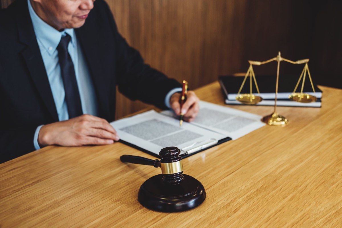A judge's gavel resting on a wooden bench in a courtroom
