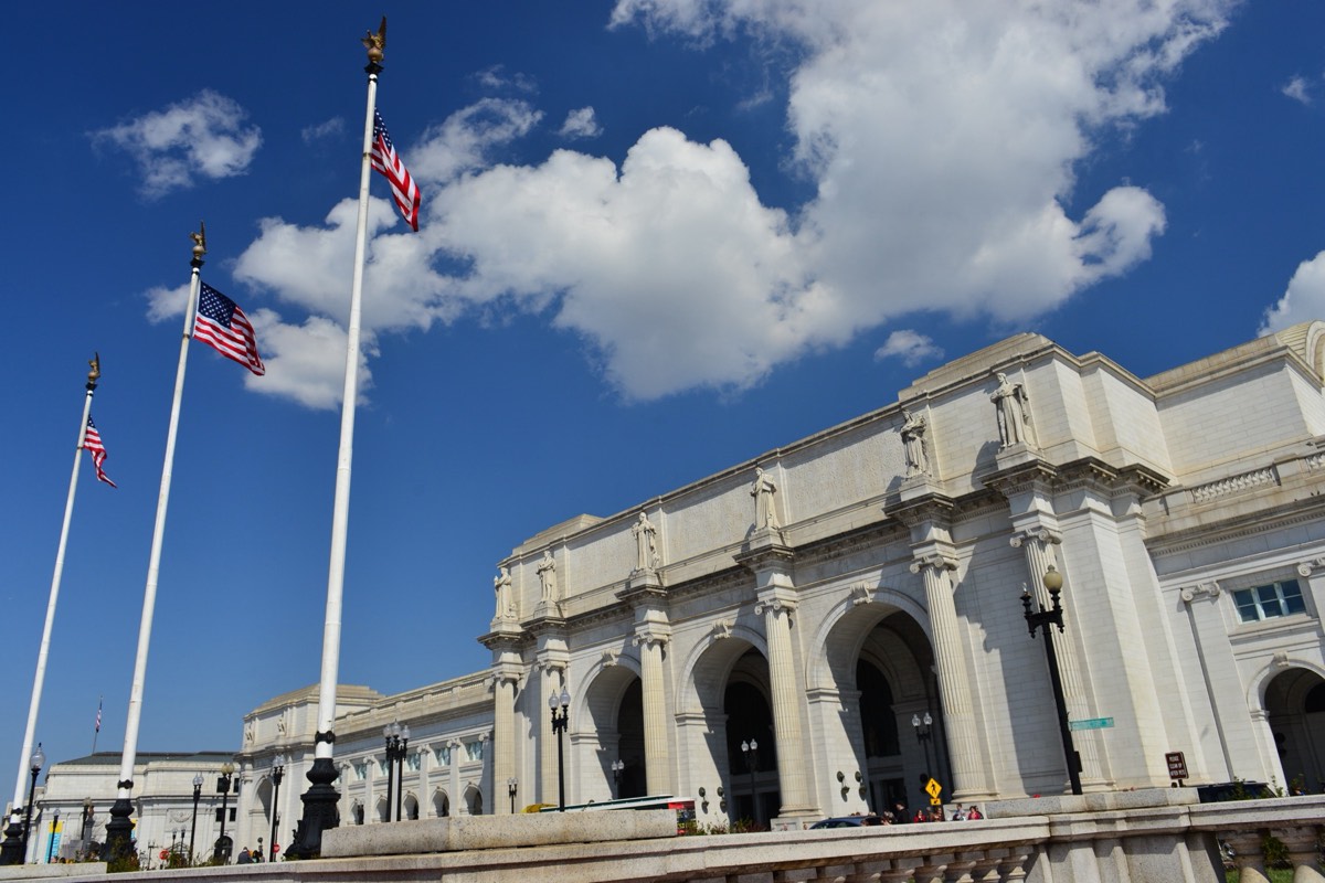A government office building with an American flag against an overcast sky