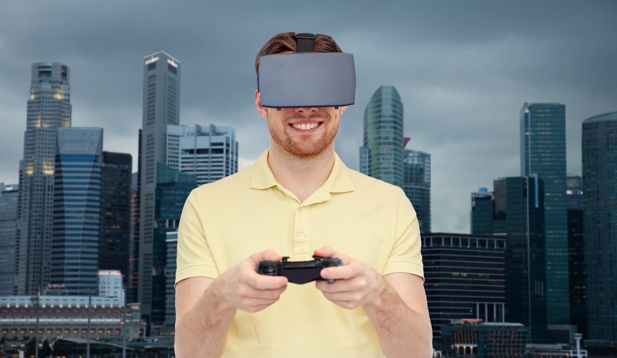 A game controller resting in front of a screen showing a stylized open-world city character