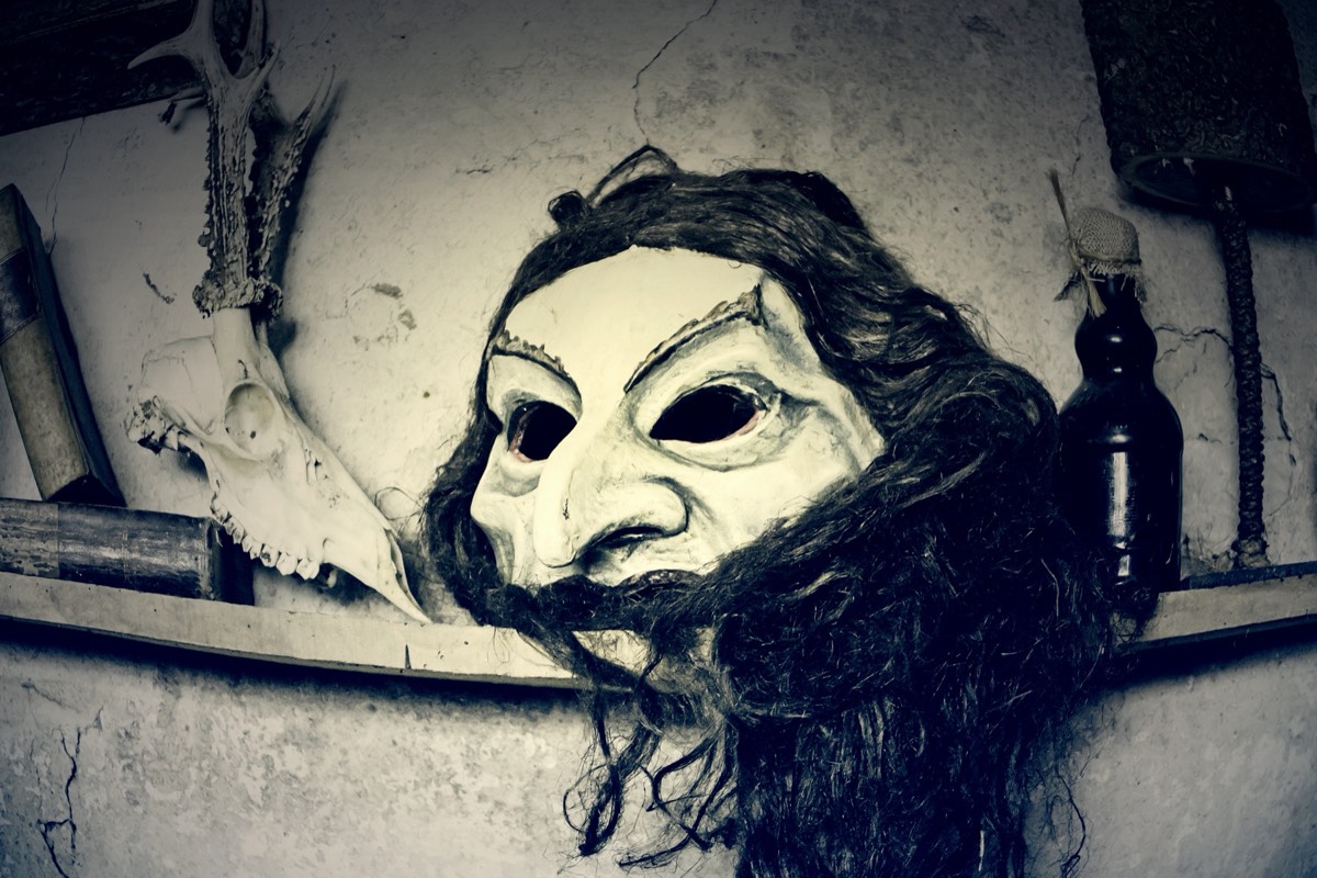 Vintage horror-film monster mask and costume props arranged on a studio table