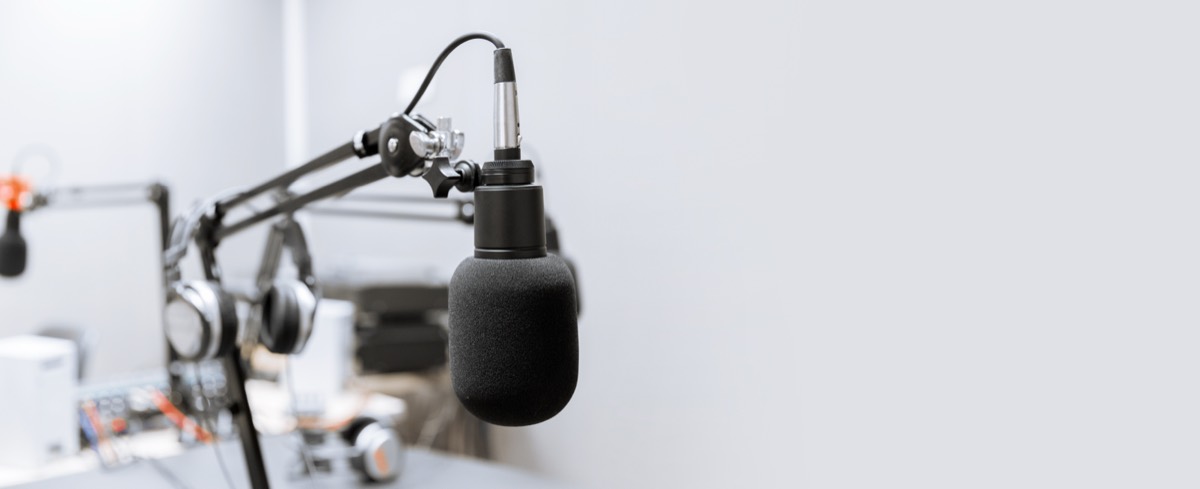 A recording studio microphone with headphones on a stand