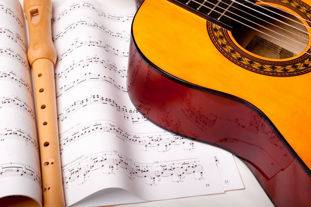 An acoustic guitar resting on sheet music