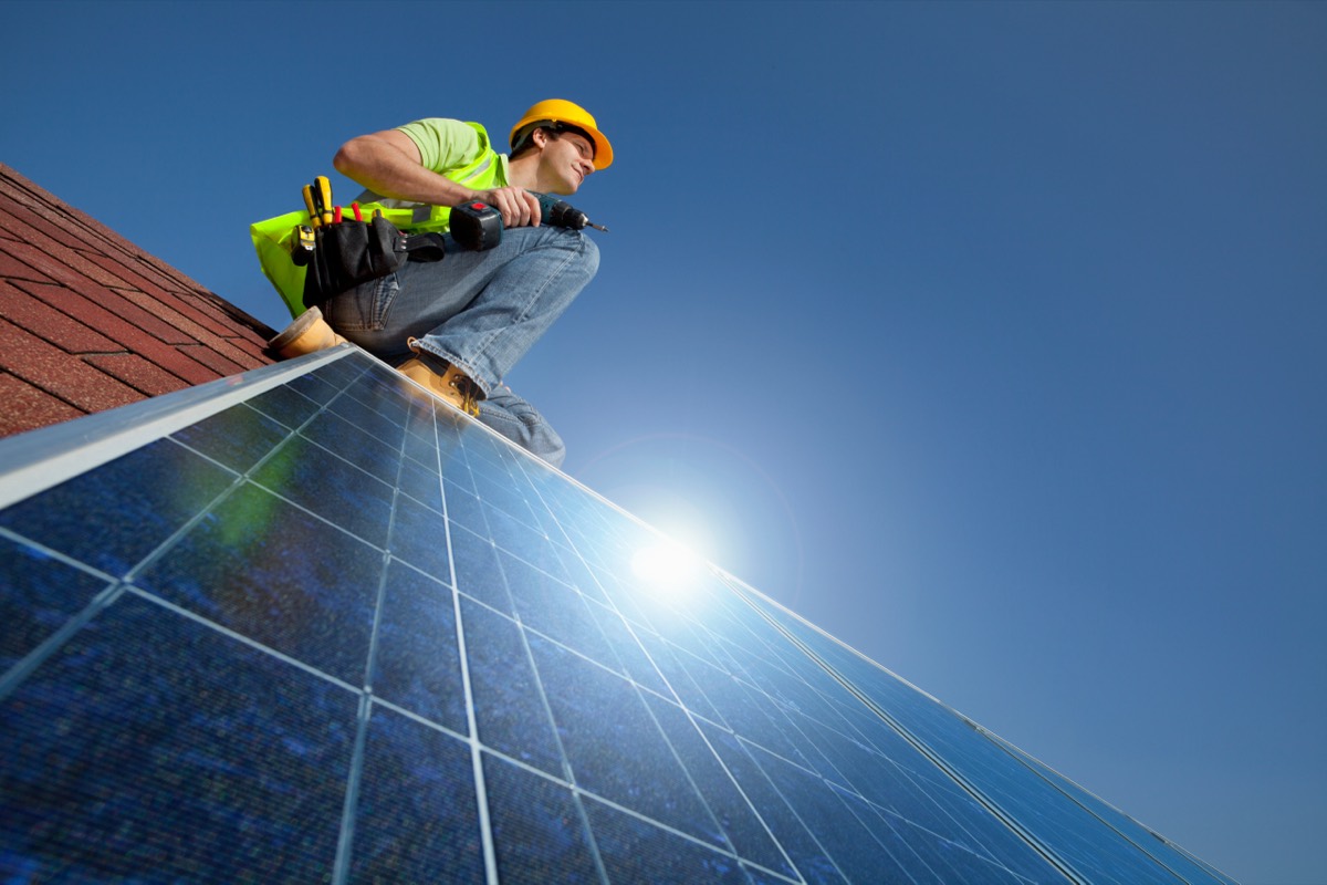 A row of solar panels on a rooftop under a clear sky