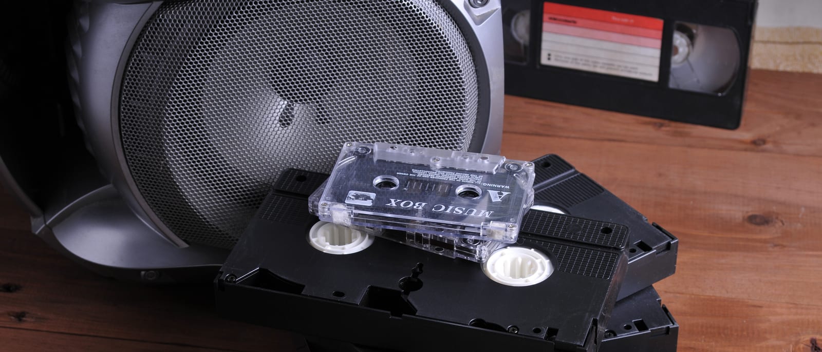 A vintage videocassette recorder and tape sitting beneath an old television set
